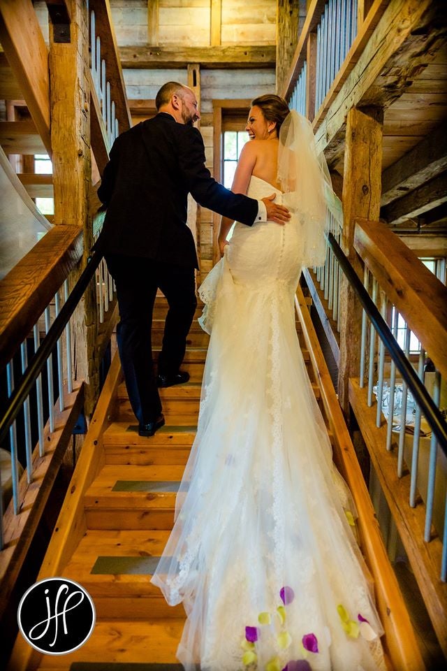 Bride and groom smiling walking up the stairs�