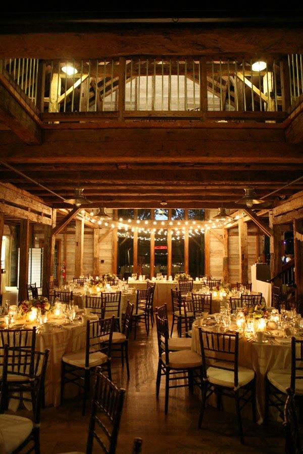 Inside of Pat's Barn reception are at night with soft lights and decorated tables.�