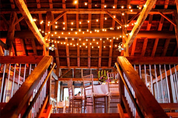 Inside of Pat's Barn showing string light decorations and decorated tables.�