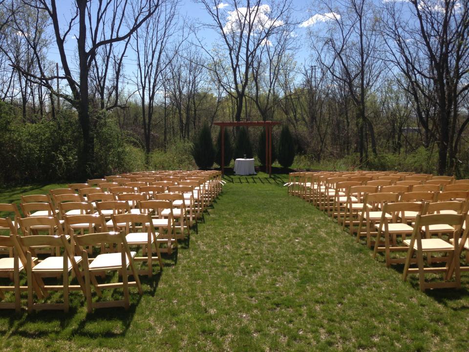 Outdoor ceremony setup at Pat's Barn showing the aisle and chairs.�