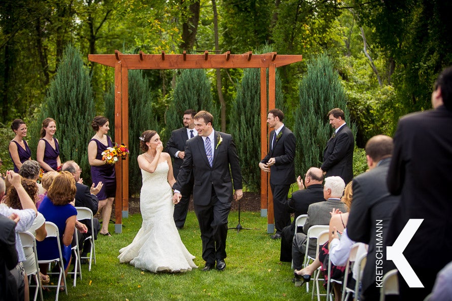 Bride and groom walking back down the aisle at an outside ceremony at Pat's Barn�